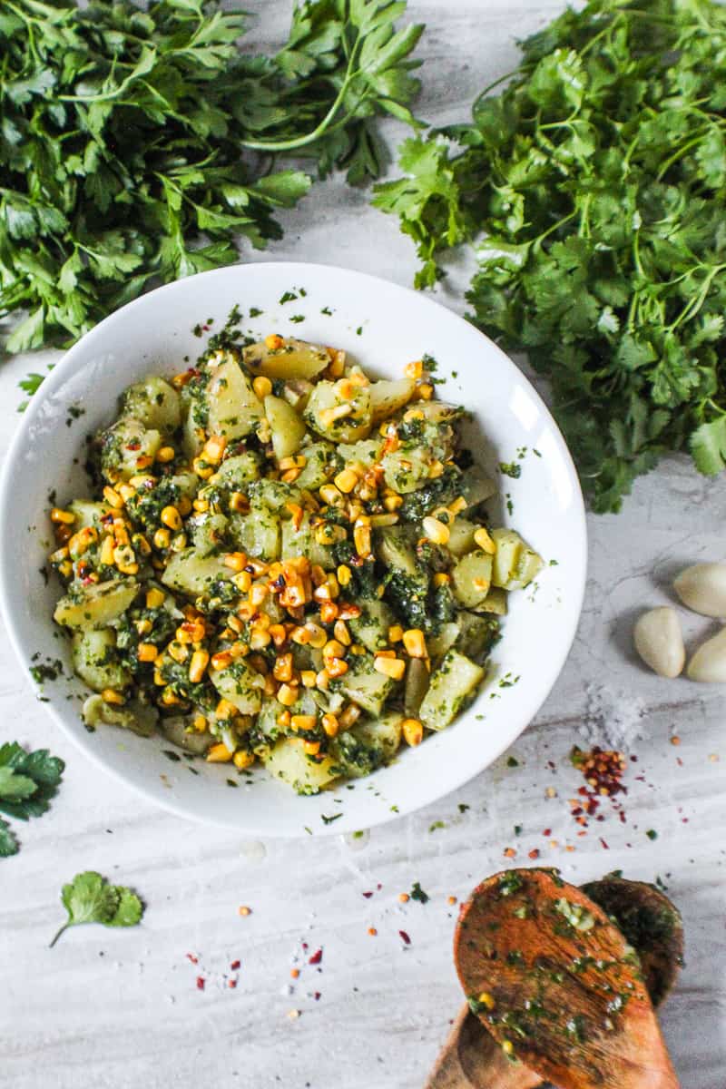 Chimichuri potato salad in bowl surrounded by ingredients