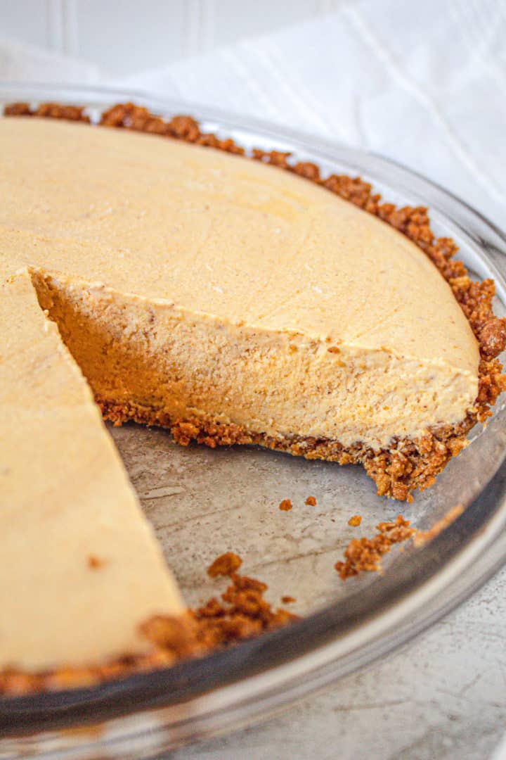 Close up of pumpkin pie ice cream pie with no-bake pie crust with slice removed