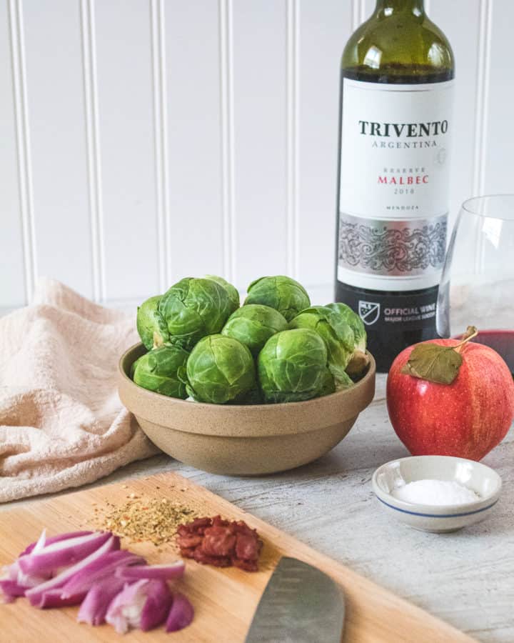 ingredients to red wine brussels sprouts  sitting on table and cutting board