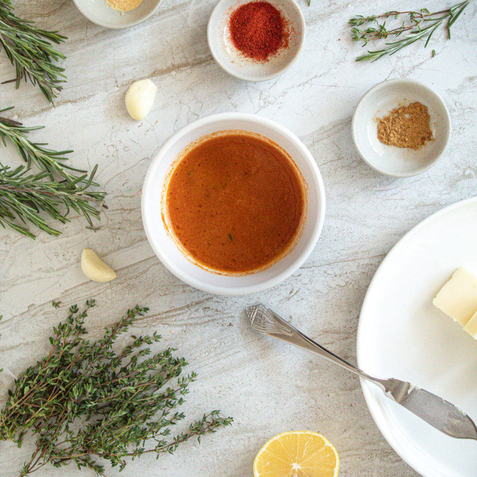 Lemon Paprika Basting Butter in bowl surrounded by bowls of ingredients
