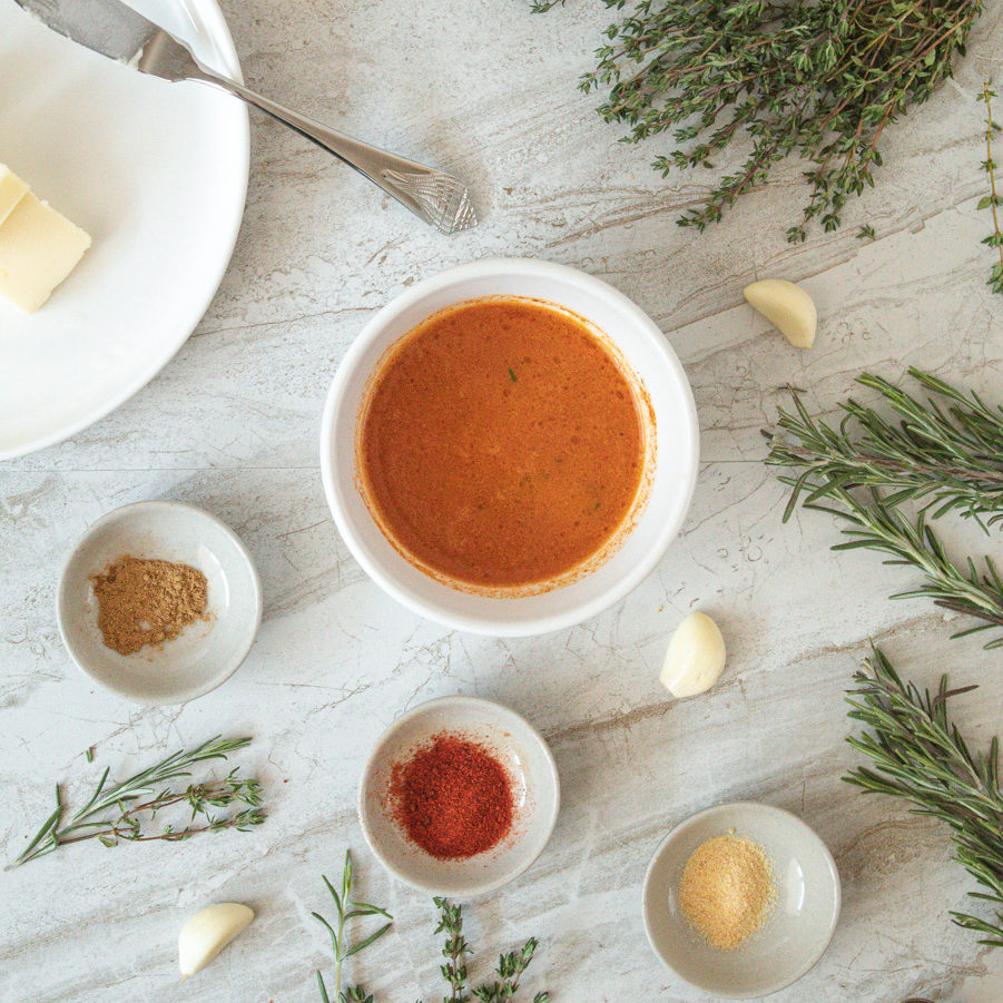 Lemon Paprika Basting Butter in bowl surrounded ingredients on table