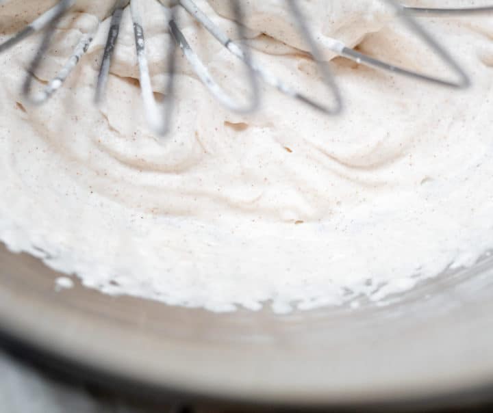 Overhead shot of drunken whipped cream in bowl being mixed with a whisk