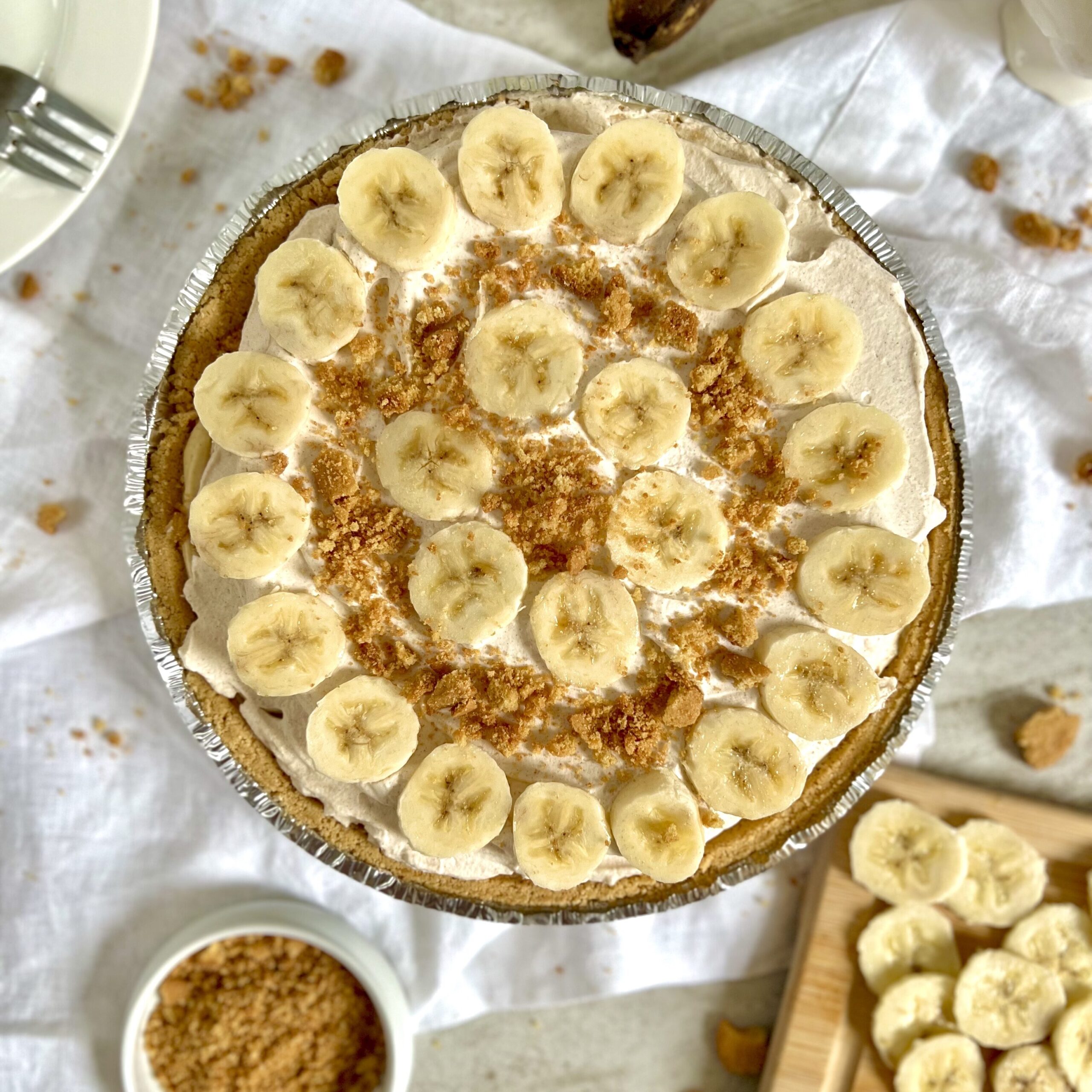 Banana Pudding Pie topped with whipped cream and decorated with rings of ripe bananas and crushed Nila wafers between rings of banana slices.